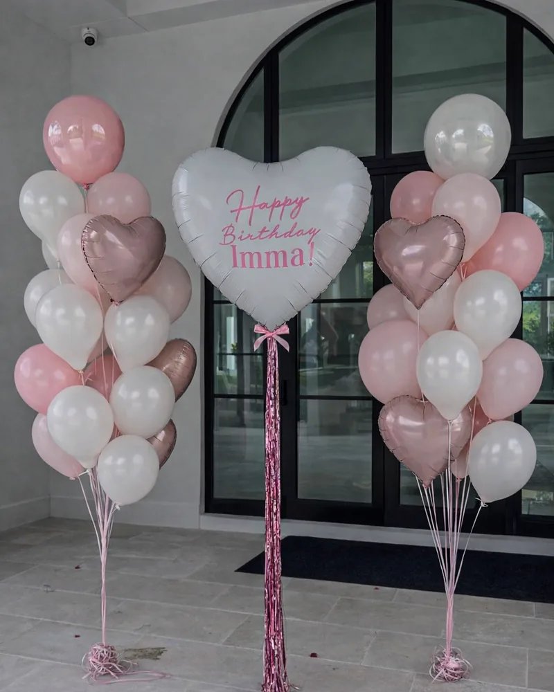 Two balloon bouquets flanking a personalised giant heart balloon