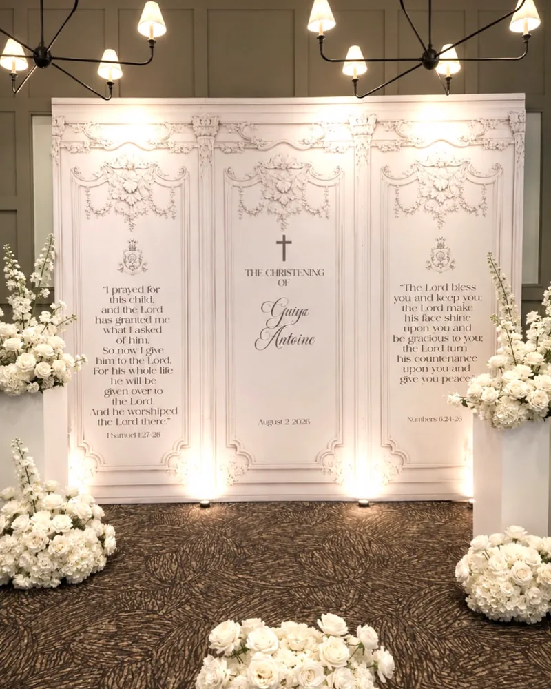 Christening backdrop with ornate printed panels and white flower arrangements