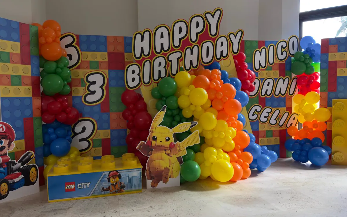 LEGO themed birthday for three children with brick panels and a primary colour garland