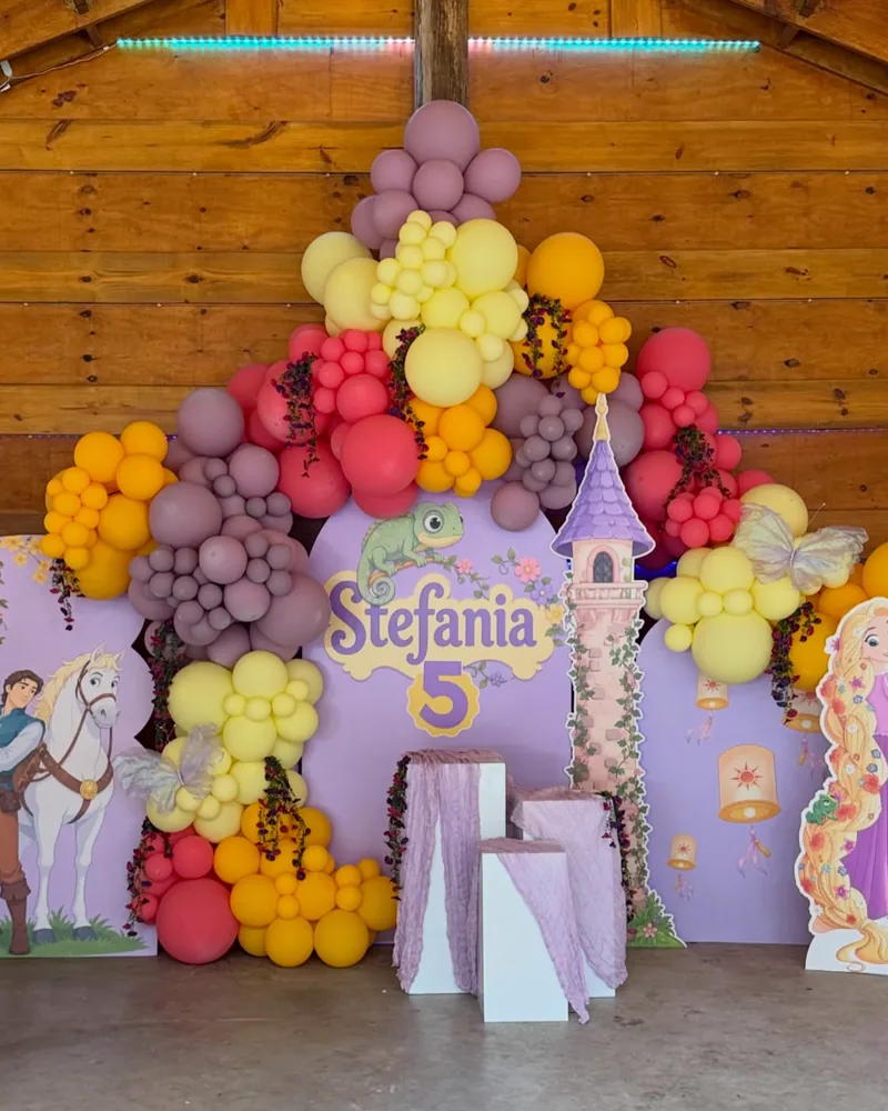 Fairytale themed birthday with printed panels, draped plinths and a warm garland