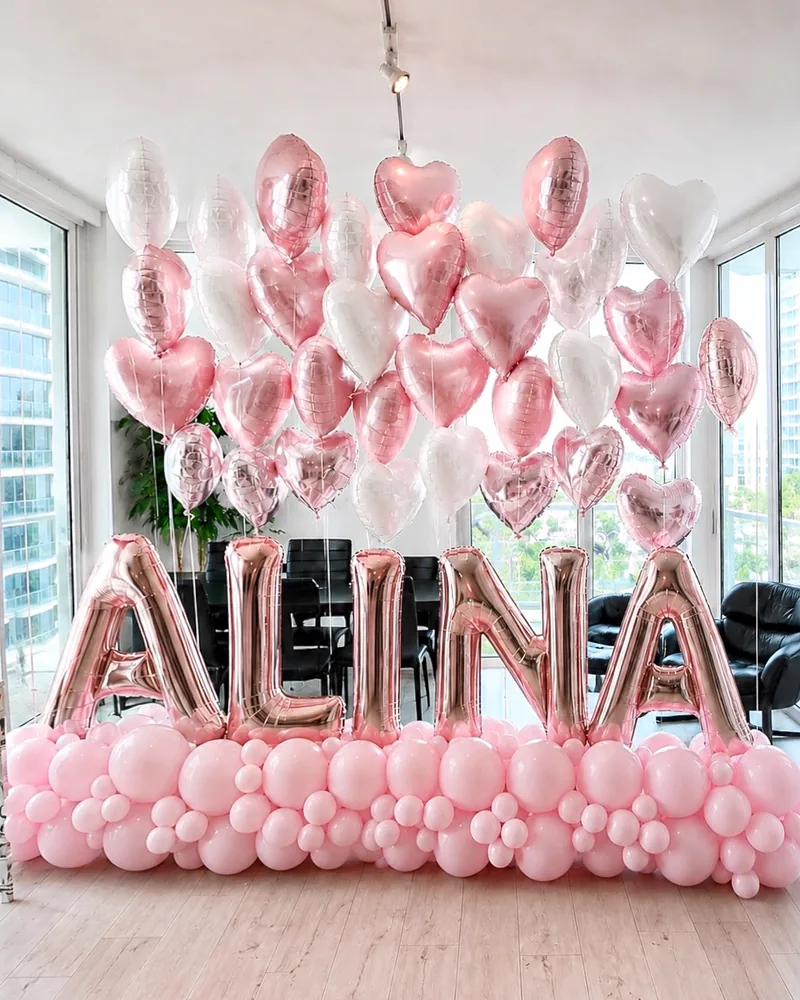 Rose gold foil name letters under a cloud of heart balloons